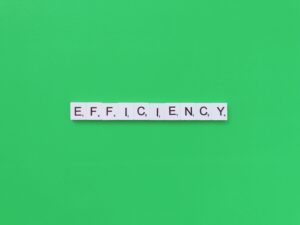 Image of blocks spelling out 'Efficiency,' highlighting workflow optimization, healthcare analytics, integrated healthcare, and care coordination.