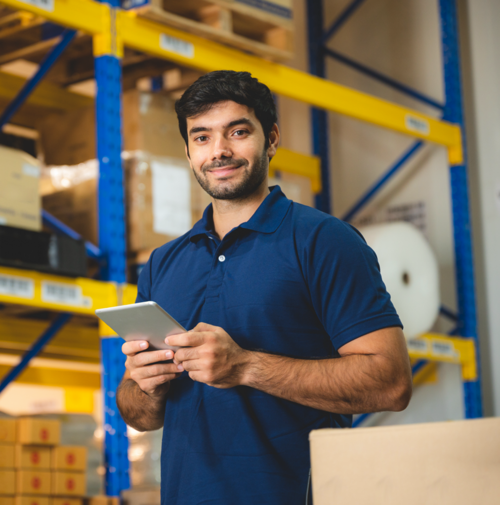 Man in a warehouse wearing a blue shirt, emphasizing medical inventory management, healthcare analytics, integrated healthcare, and compliance management systems.